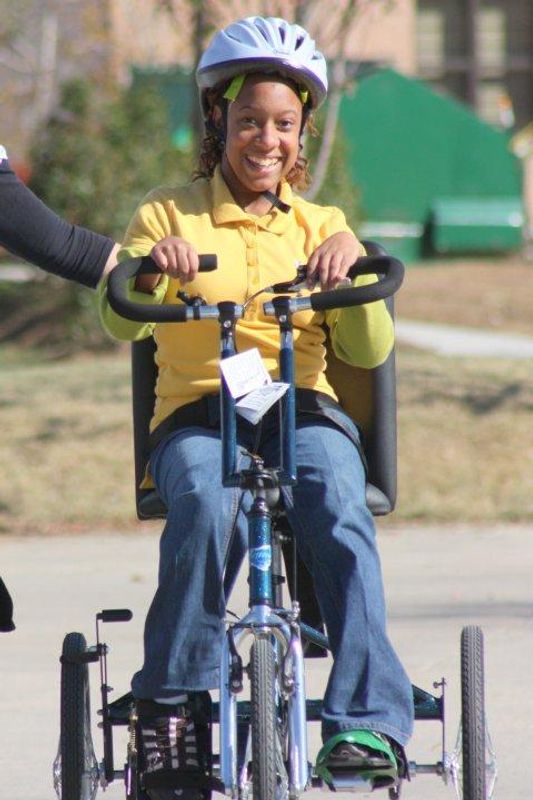Child with new cycle from Wheels to Succeed and Alvarez Construction Company, LLC