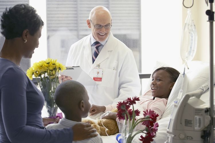 a doctor consults with a young patient and her family