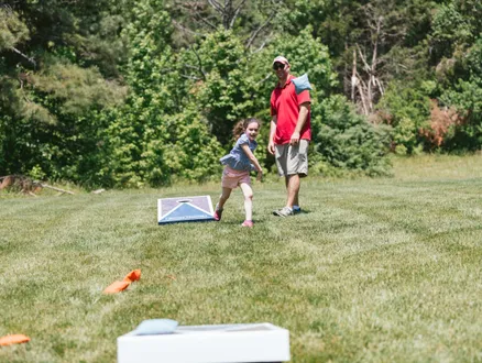 dad and daughter playing cornhole