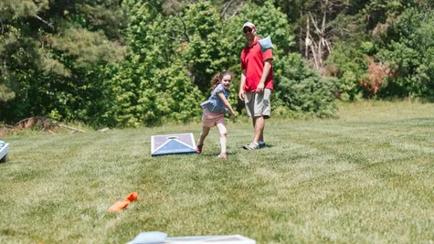 dad and daughter playing cornhole