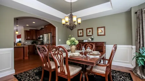 Elegant Dining Room with Tray Ceiling, Crown Moulding and Wainscoting