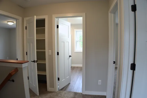View of the upstairs landing with doors to bedrooms, full bath and hall closet