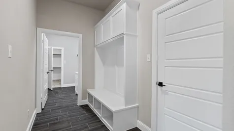 Mudroom with a mud bench and a separate laundry room.