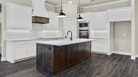 White Painted Shaker cabinets with a kicthen island with a sink and white tile backsplash.