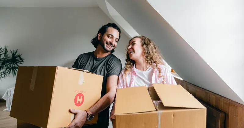 Couple packing boxes to move into their new home