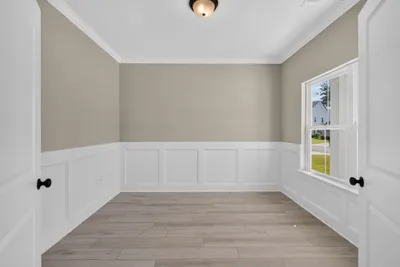 Interior corner of the first-floor den at 186 Hanover Place highlighting the large double-hung window and neutral wall finishes.