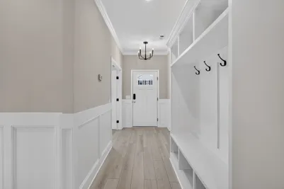 Interior foyer at 186 Hanover Place featuring craftsman-style wainscoting, a built-in drop zone bench, and access to the first-floor den.