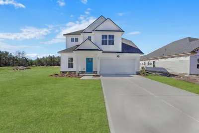 Sherwood B two-story home with white siding, a blue front door, covered entry and two-car garage.
