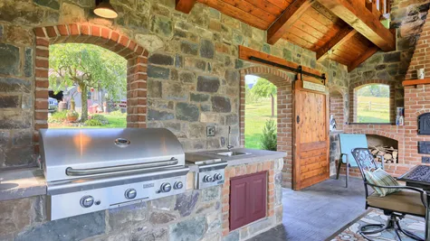 Outdoor patio with seating and brick fireplace from Garman Builders