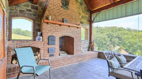 Outdoor patio with seating and brick fireplace from Garman Builders