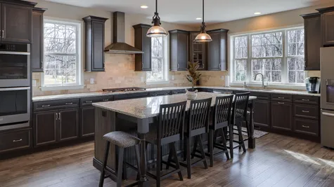 Kitchen with brown cabinets and a center island in a remodeled home from Garman builders