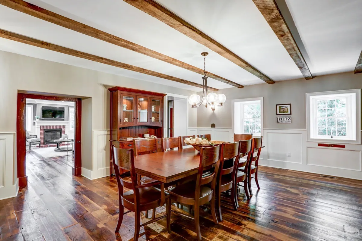 Remodeled dining room with exposed beams, hardwood floors and wooden dining room table
