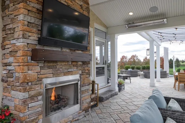 Outdoor patio with a brick fireplace and couches from Garman builders