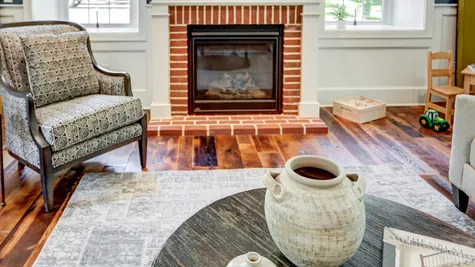 Living room with brick fireplace in a remodeled home from Garman builders