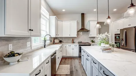 Kitchen with white cabinets and center island in the Abigail Model from Garman Builders