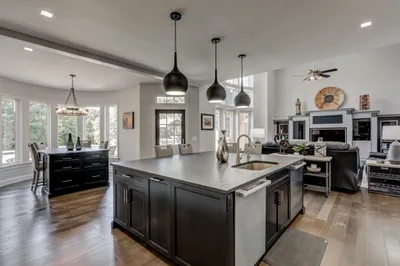 Remodeled kitchen with center island, black pendant lights, and open concept