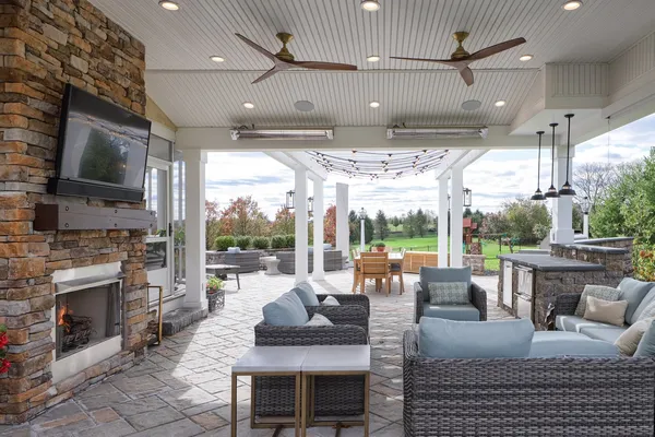 Outdoor patio with a brick fireplace and couches from Garman builders