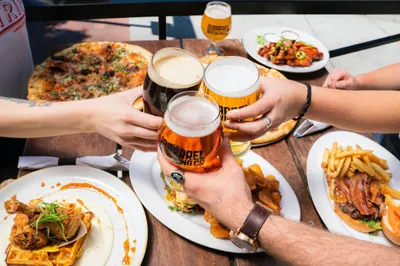 people with beer and food at a table
