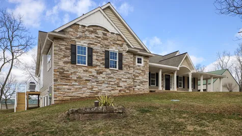 Front of a remodeled tan home with stone accents from Garman Builders