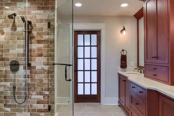 full bathroom with large glass door shower in a Garman Builders remodel
