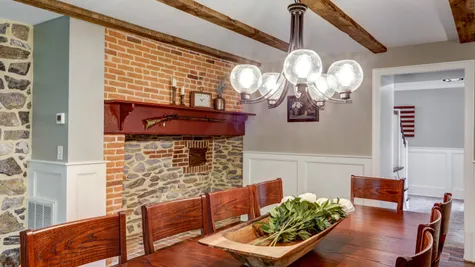 Dining room with a stone wall and large table in a remodeled home from Garman builders