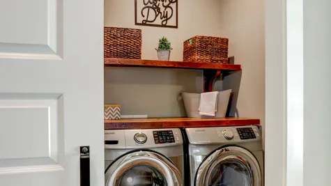 Laundry room with installed shelves in a remodeled home from Garman builders