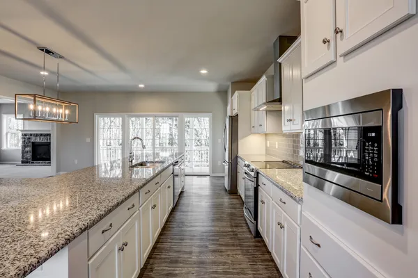 Kitchen with white cabinets and long center island in a Garman Builders Home