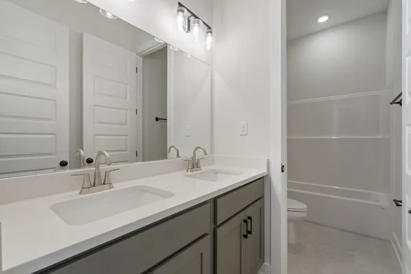 Double vanity featuring light-toned countertops and undermount sinks