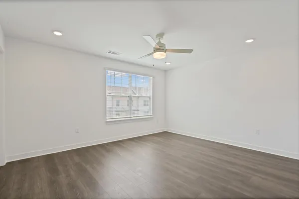 Wood-finish flooring, recessed lighting, ceiling fan with integrated light, and window with blinds