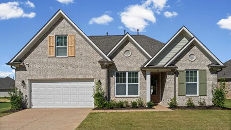 Brick exterior with gabled rooflines, a two-car garage, and a covered entry