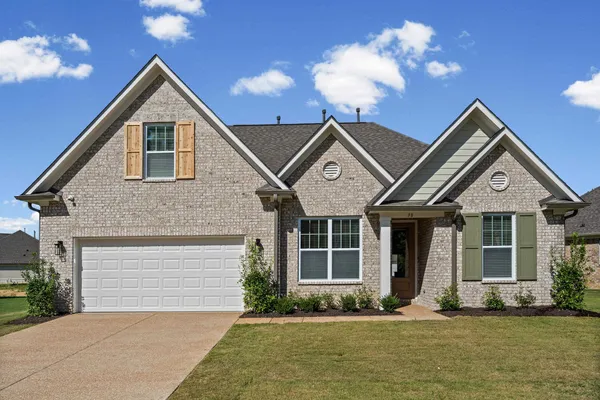 Brick exterior with gabled rooflines, a two-car garage, and a covered entry