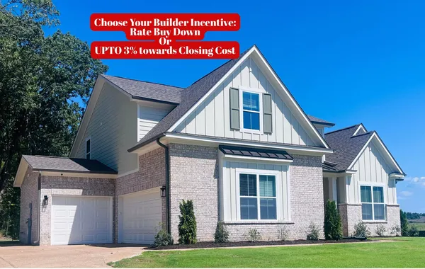 Two-story exterior featuring a brick and board-and-batten facade, multi-gabled roofline, dual-bay garage, and dark-toned shutter accents