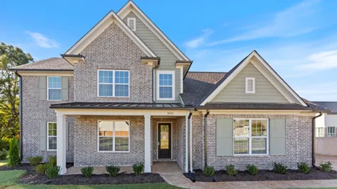 Multi-gabled exterior featuring brick masonry, horizontal siding, decorative shutters, a covered front porch with square columns, and architectural roofing shingles