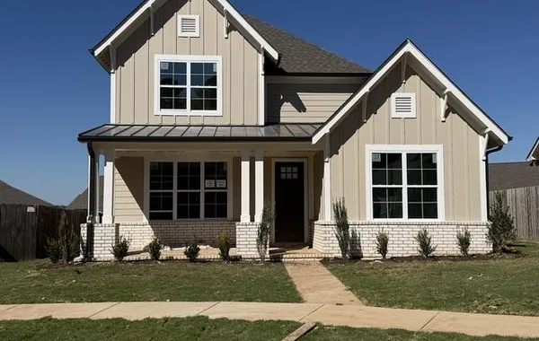Two-story exterior featuring a gabled roof, horizontal siding, and a covered entry