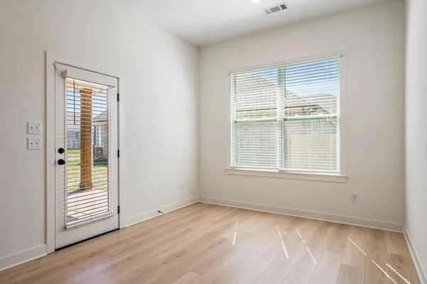 Wood-finish flooring, white walls, and a large window with blinds