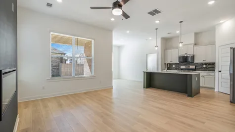 Light wood-finish flooring throughout, recessed lighting, and a ceiling fan