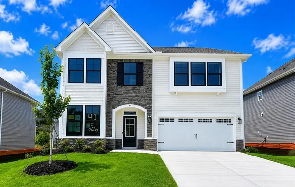 Crisp white siding paired with stone accents defin