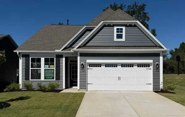 A neat concrete driveway leads directly to a class