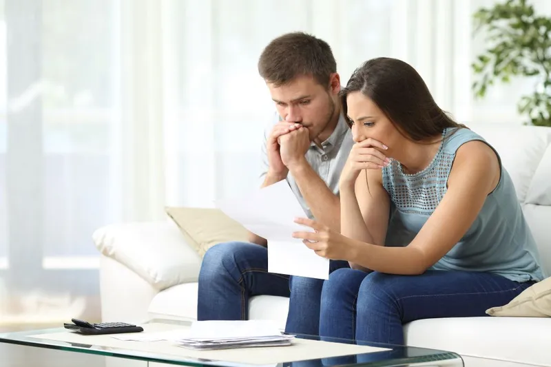 Couple looking worried while reading off a piece of paper