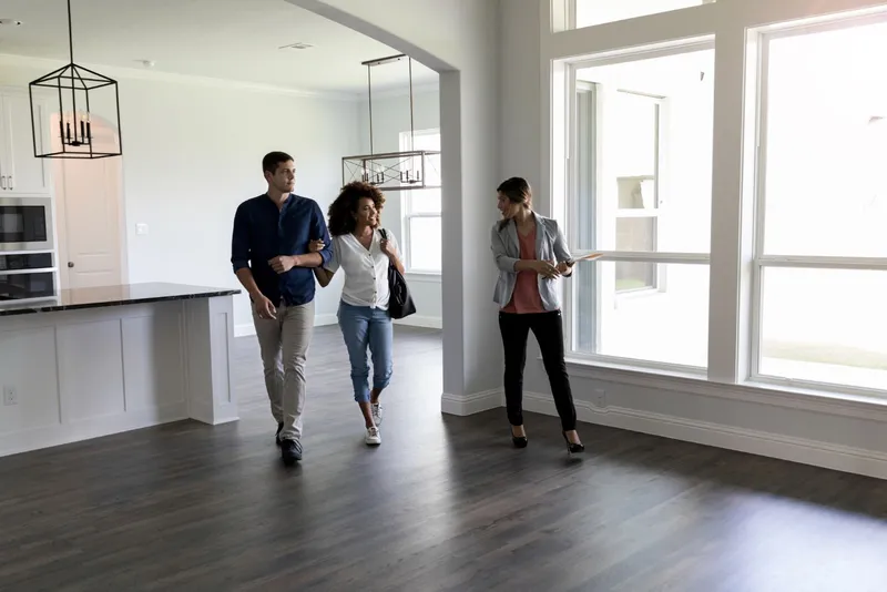 Realtor Showing a Couple Through an Empty Kitchen