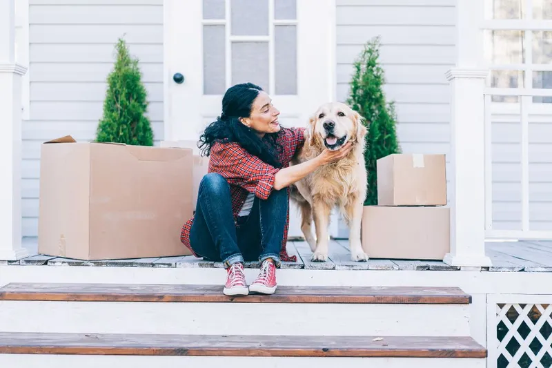 Woman Petting Her Dog on the Porch While Moving