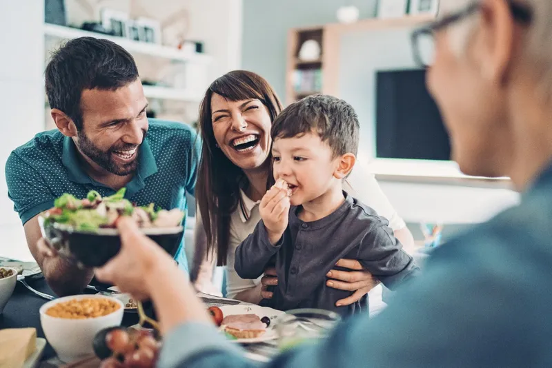 Family Laughing and Enjoying a meal Together