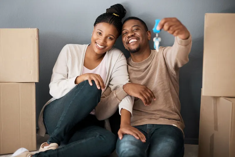 Couple Celebrating Their New Home by Holding the Keys Up