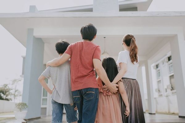 Family Standing in Front of Newly Built Home