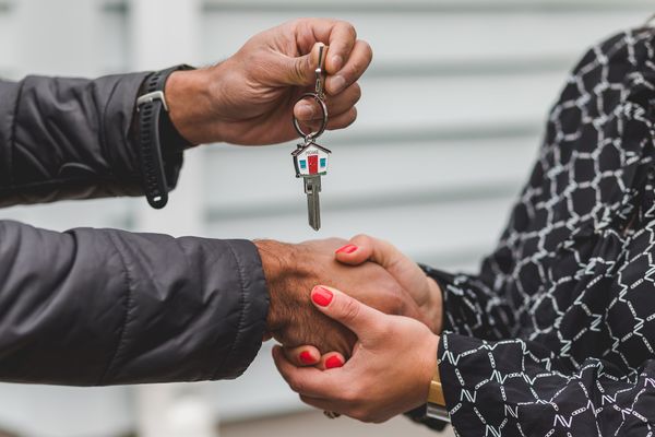 Person Holding Silver Key To Their New Home