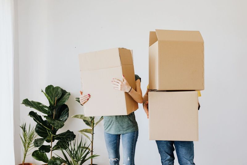 2 People Holding Moving Boxes