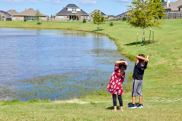  Kids throwing rocks in pond in Native Plains - new homes in Moore, OK