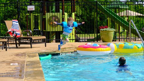 Child jumping into pool in Little River Trails - new homes in Norman, OK