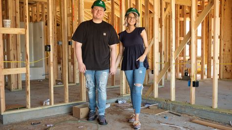  Man and woman standing inside home under construction