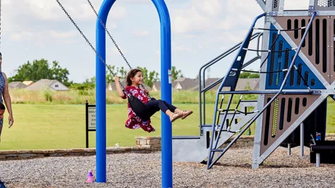  Girl swinging at playground in Native Plains - new homes in Moore, OK